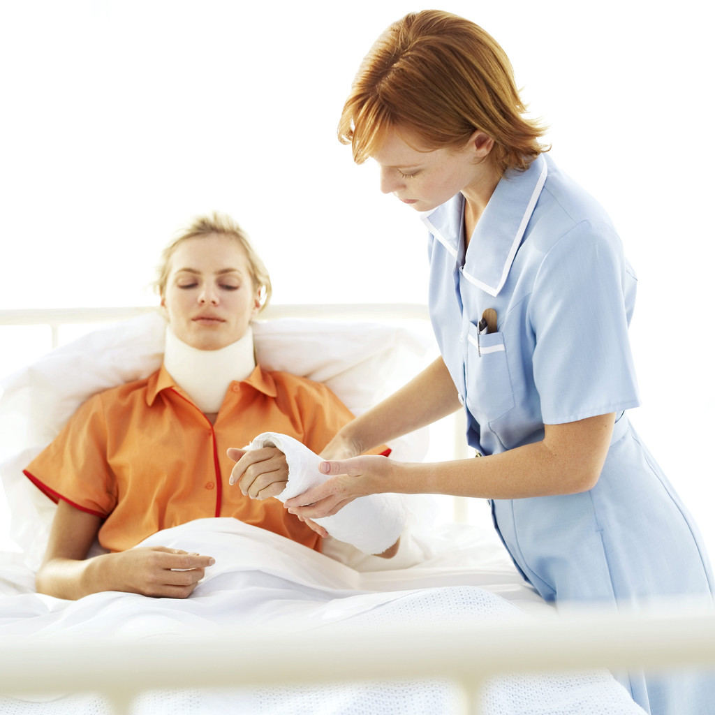 Young Nurse Tending to Young Woman with Neck Brace and Arm Cast